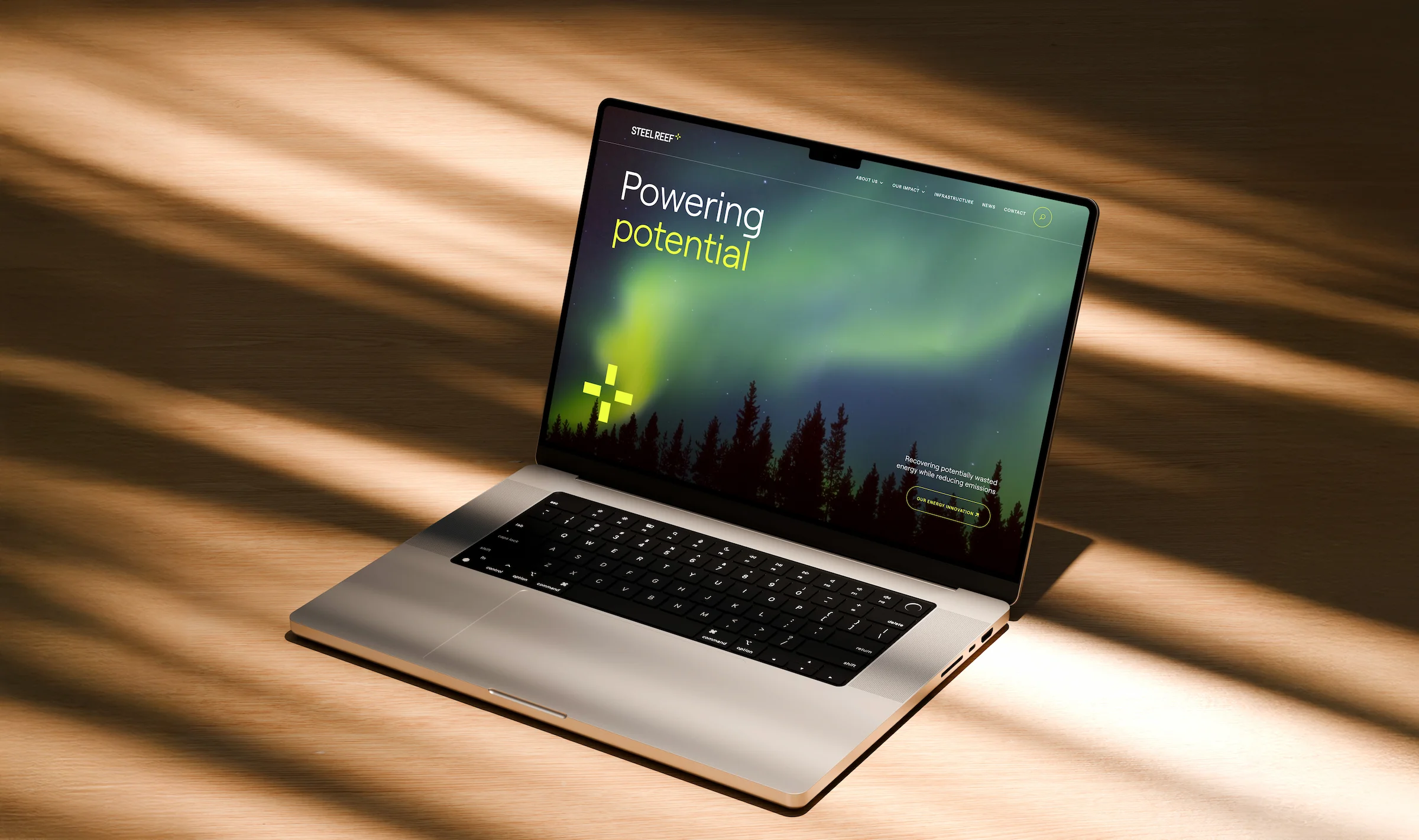 Homepage hero on a laptop sitting on a wooden table.